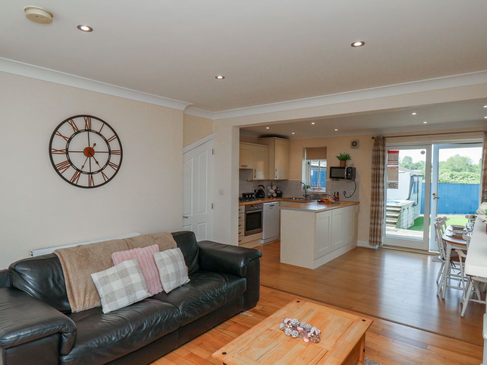 A living room with a sofa and kitchen area at The Cosy Haven in Malton