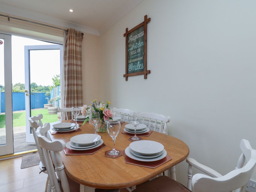 A dining room with a table set for meals at The Cosy Haven in Malton