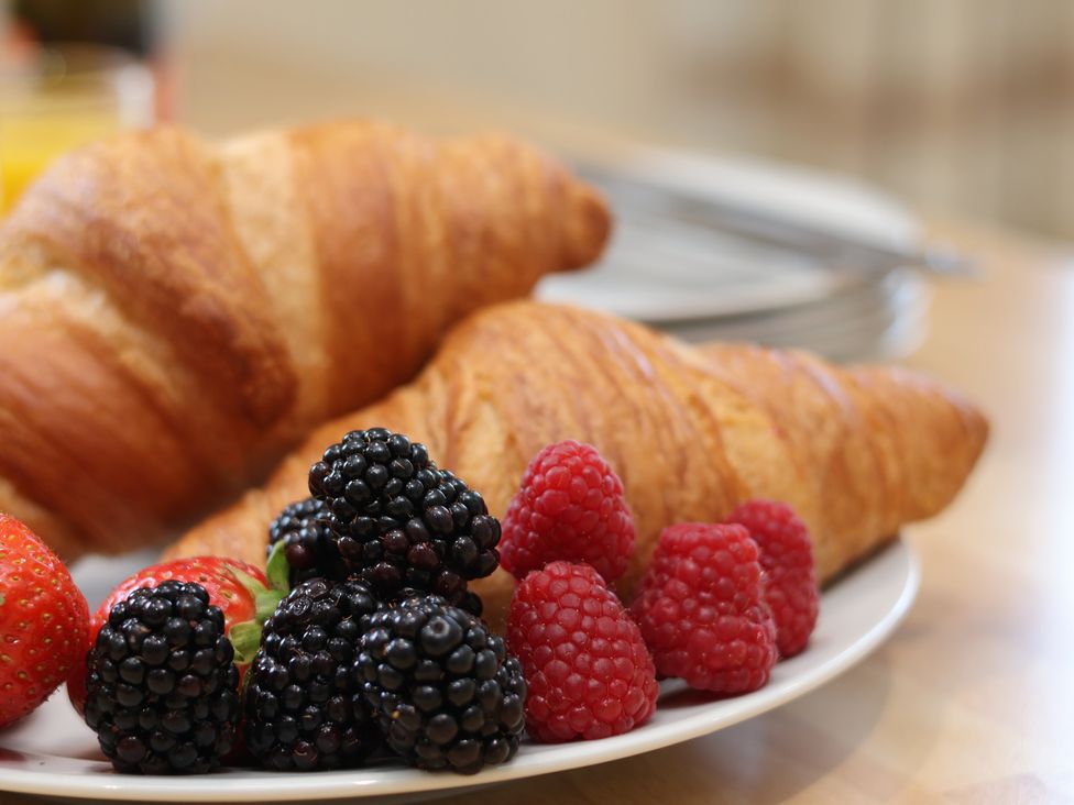 A plate with croissants and assorted berries at The Cosy Haven in Malton
