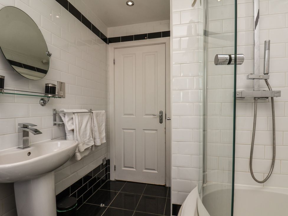 A bathroom with a sink, mirror, and shower at The Cosy Haven in Malton