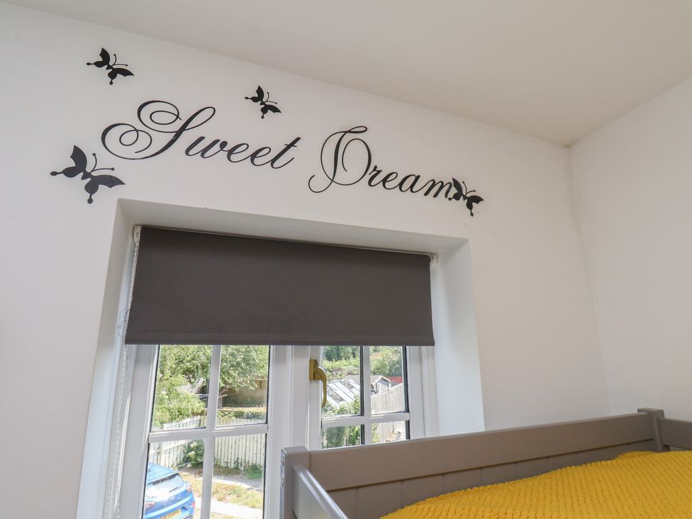 A bedroom with a window and a yellow blanket at The Cosy Haven in Malton