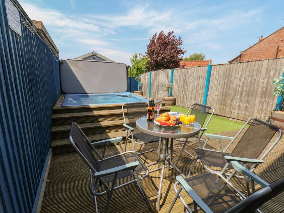 An outdoor area with a hot tub and seating at The Cosy Haven in Malton