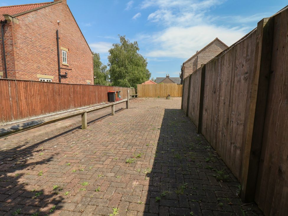 An outdoor space with a paved area and wooden fence at The Cosy Haven in Malton