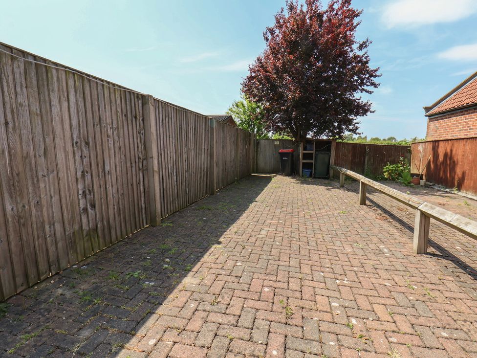 A garden with a tree and benches at The Cosy Haven in Malton
