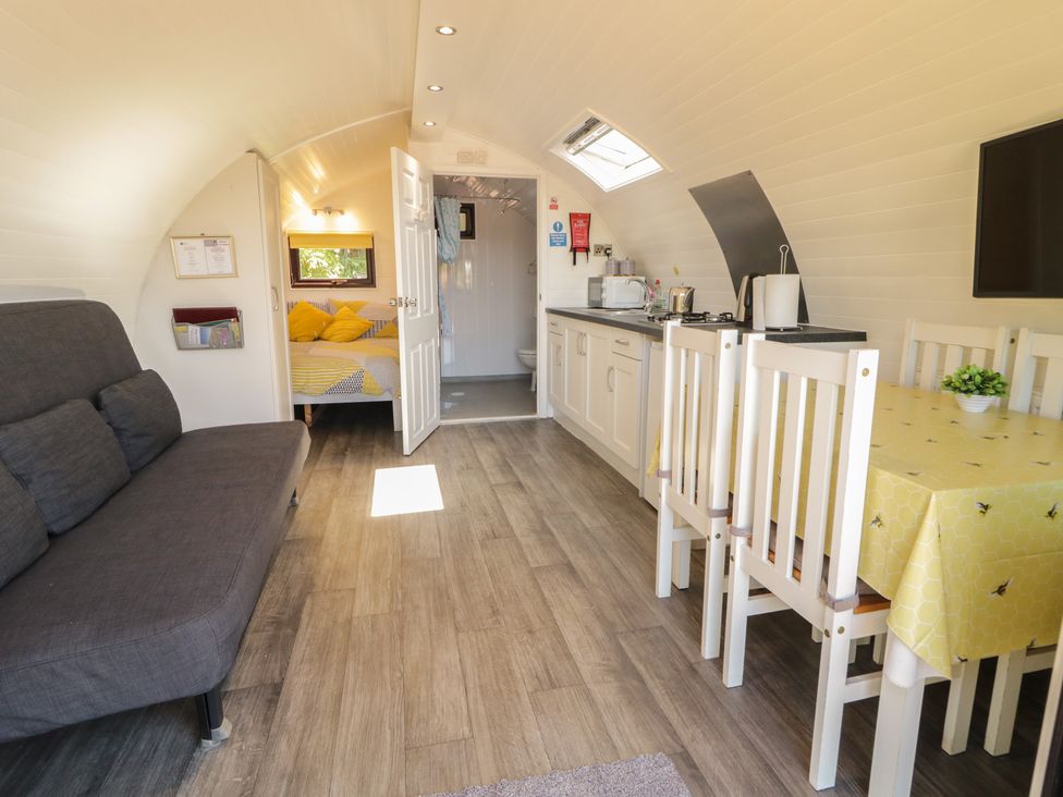 A living room with a sofa and dining area at Gortin Glen Glamping Pod 2 Omagh