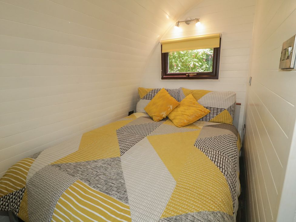 A bedroom with a bed and a window at Gortin Glen Glamping Pod 2 in Omagh