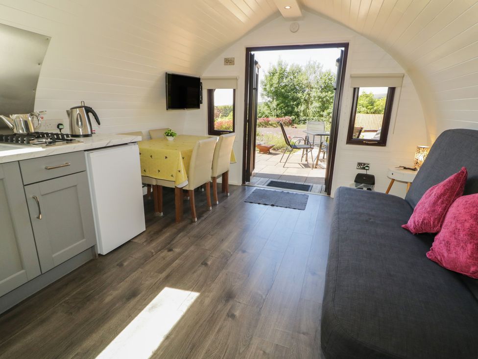 A kitchen area with dining table and chairs at Gortin Glen Glamping Pod 3 in Omagh