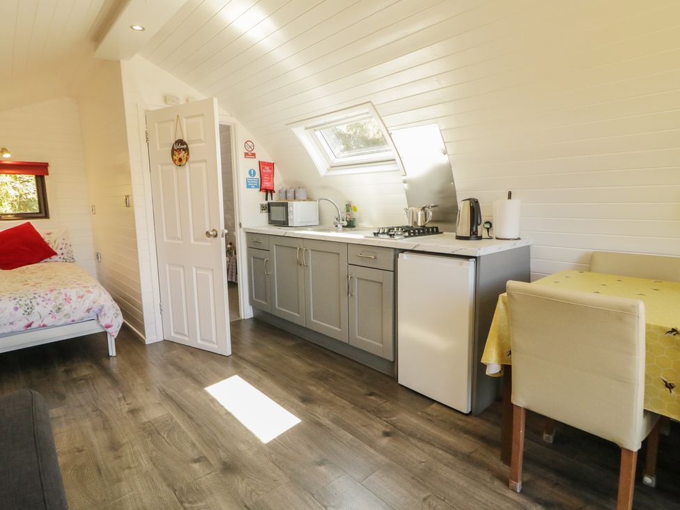 A kitchen with a bed and dining area at Gortin Glen Glamping Pod 3 in Omagh