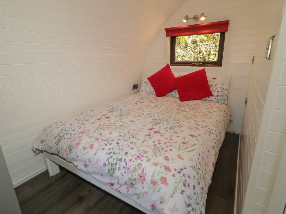 A bedroom with a double bed and window at Gortin Glen Glamping Pod 3 Omagh