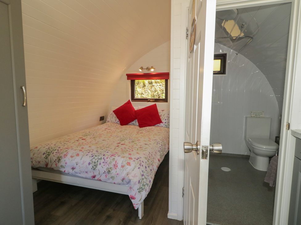 A bedroom with a bed and an attached bathroom at Gortin Glen Glamping Pod 3 in Omagh