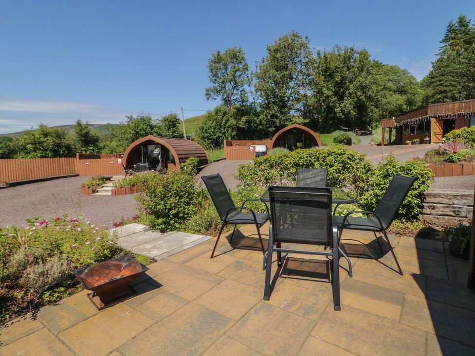 An outdoor seating area with a table and chairs at Gortin Glen Glamping Pod 3 in Omagh