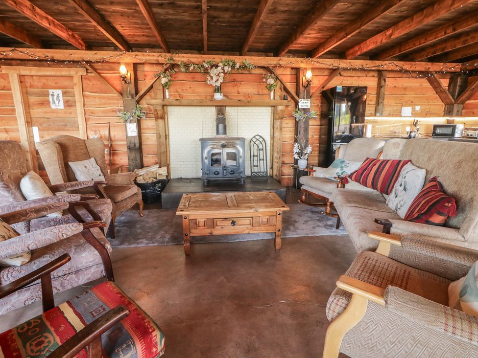 A living room with sofas and a fireplace at Gortin Glen Glamping Pod 3 in Omagh