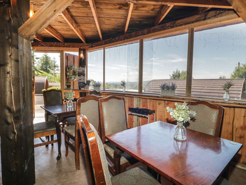 A dining area with wooden table and chairs at Gortin Glen Glamping Pod 3 Omagh