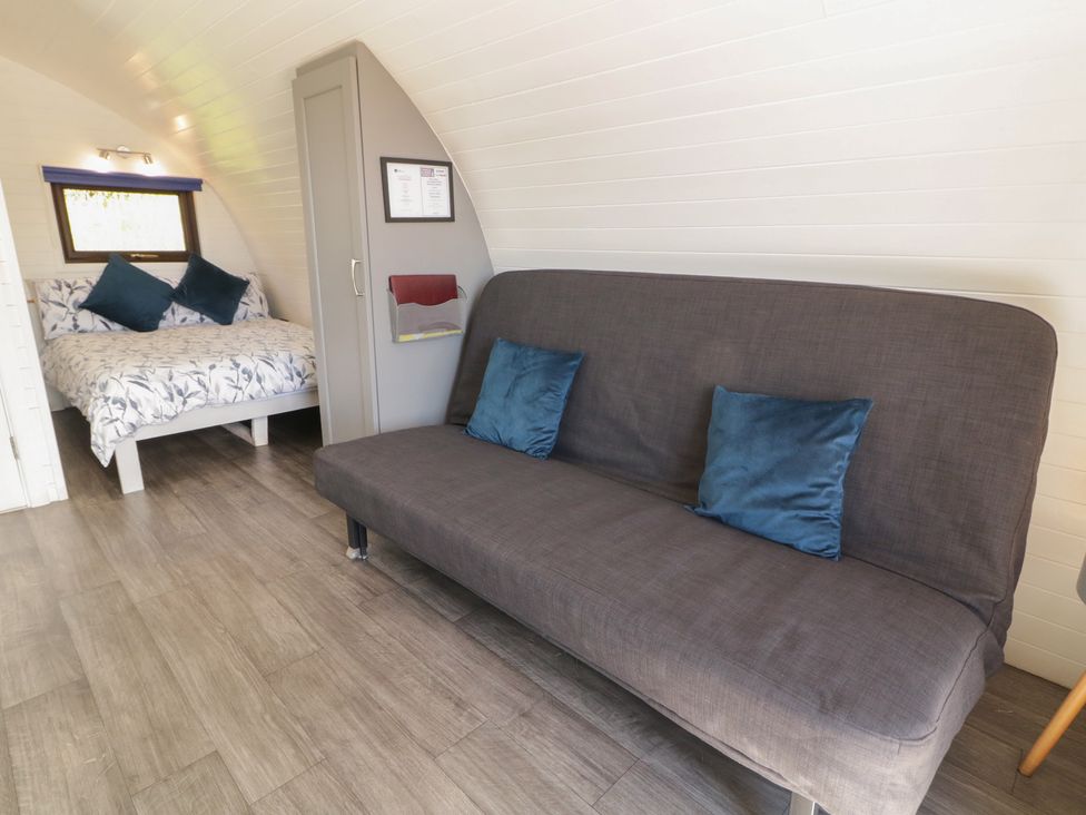 A bedroom with a bed and couch at Gortin Glen Glamping Pod 4 in Omagh