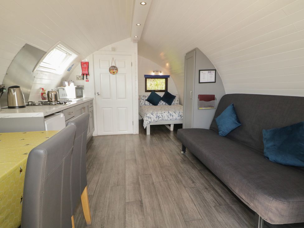A living room with kitchen appliances and a sofa at Gortin Glen Glamping Pod 4 in Omagh