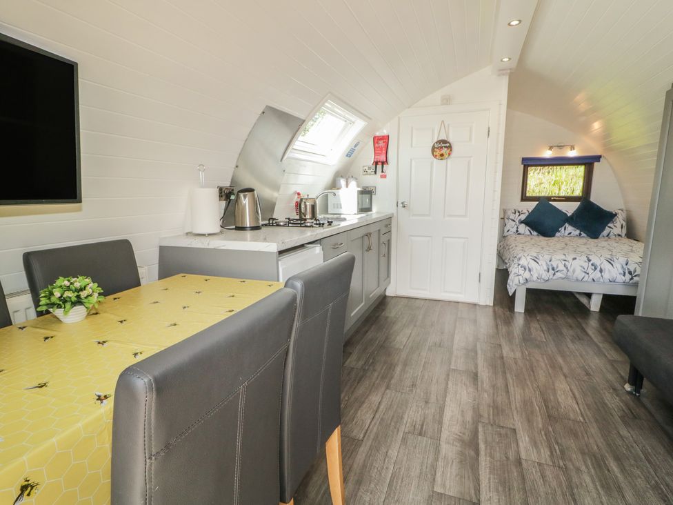 A kitchen area with a dining table and chairs at Gortin Glen Glamping Pod 4 in Omagh