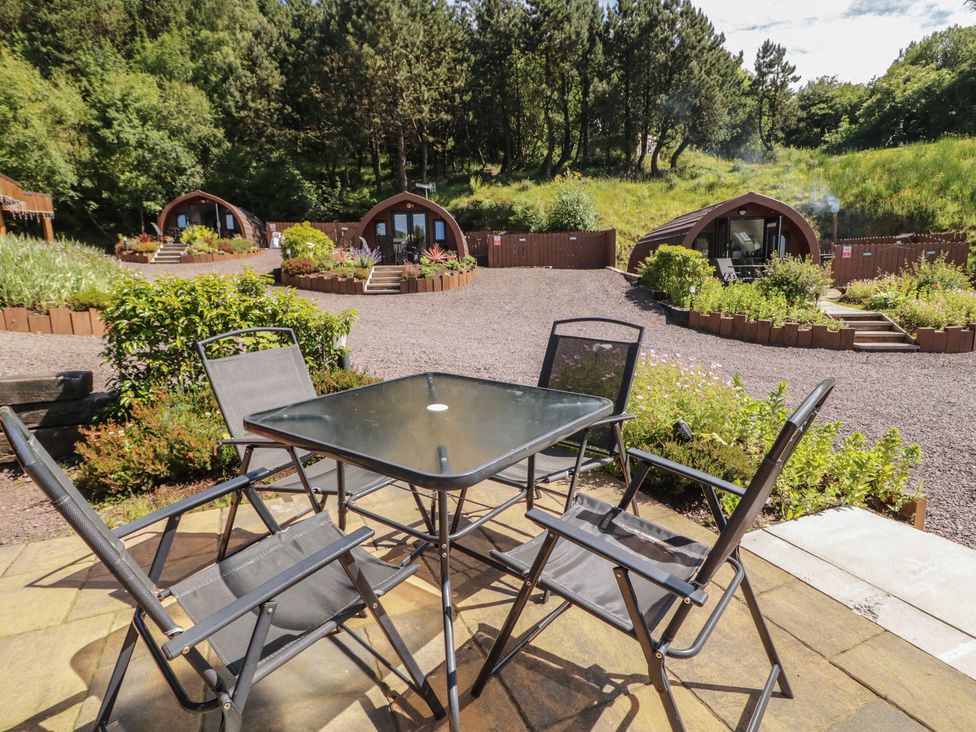 An outdoor seating area with a table and chairs at Gortin Glen Glamping Pod 4 in Omagh