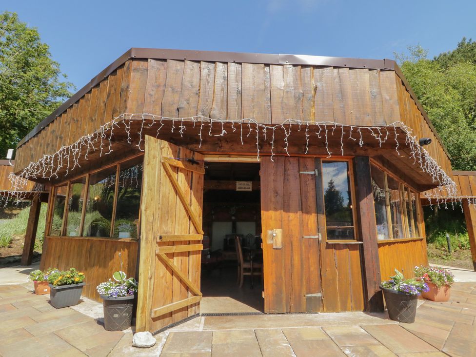 A wooden building entrance with potted plants at Gortin Glen Glamping Pod 4 in Omagh