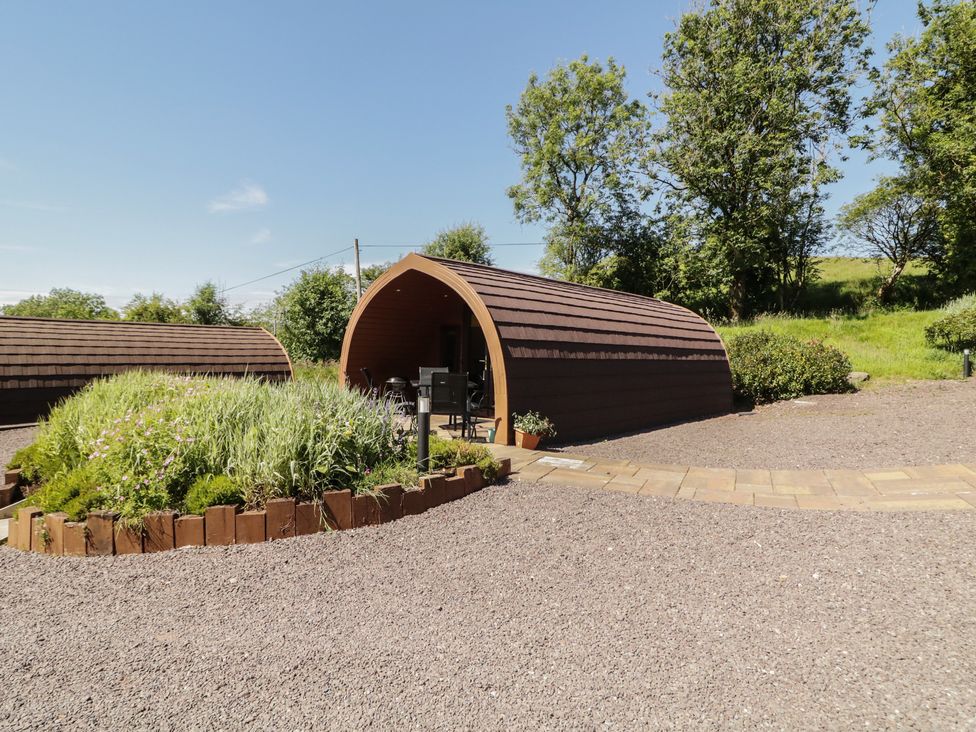 An outdoor area with a glamping pod and flower beds at Gortin Glen Glamping Pod 5 Omagh