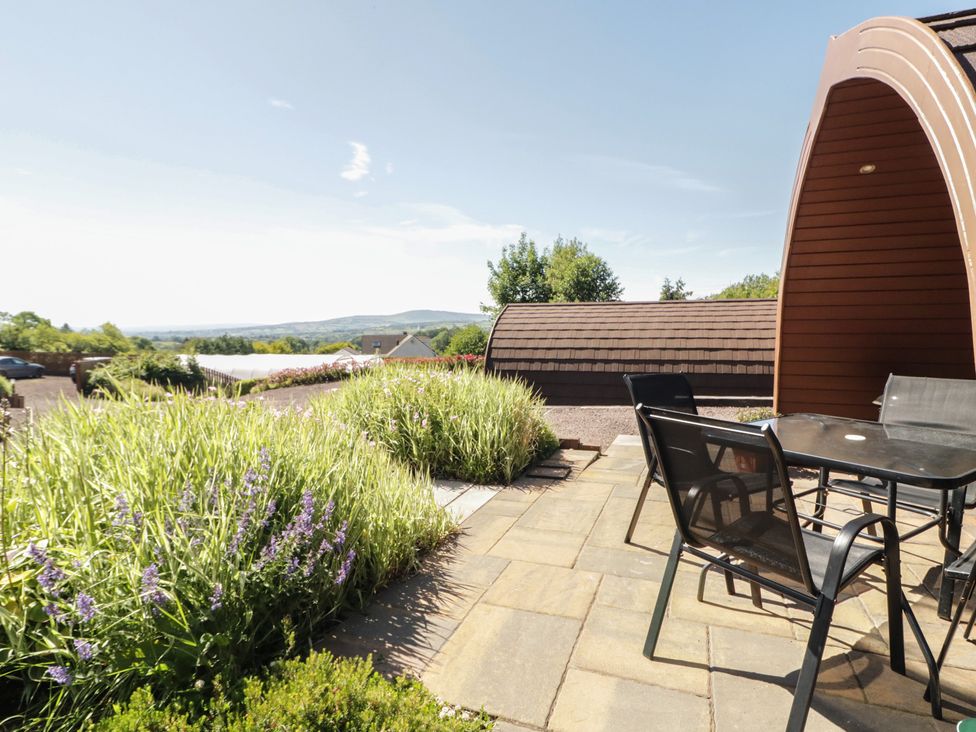 An outdoor seating area with a table and chairs at Gortin Glen Glamping Pod 5 Omagh