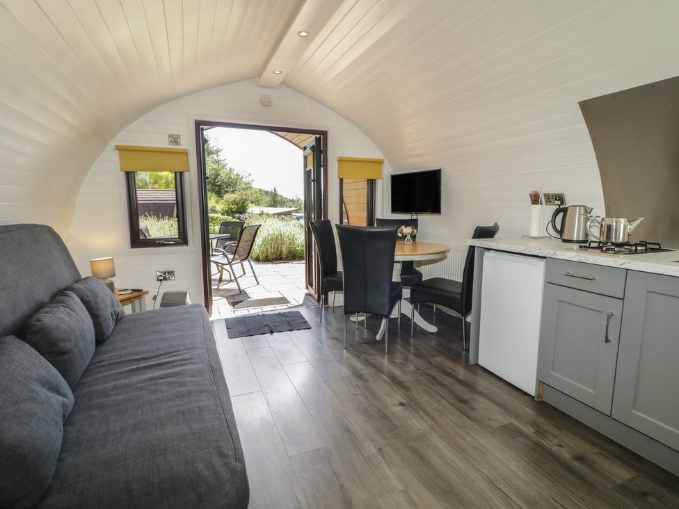 A living room with a kitchenette and dining area at Gortin Glen Glamping Pod 5 in Omagh