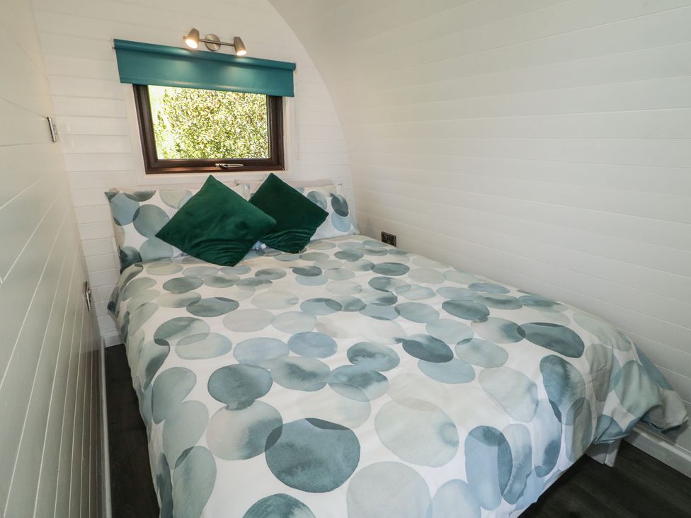 A bedroom with a double bed and window at Gortin Glen Glamping Pod 5 Omagh