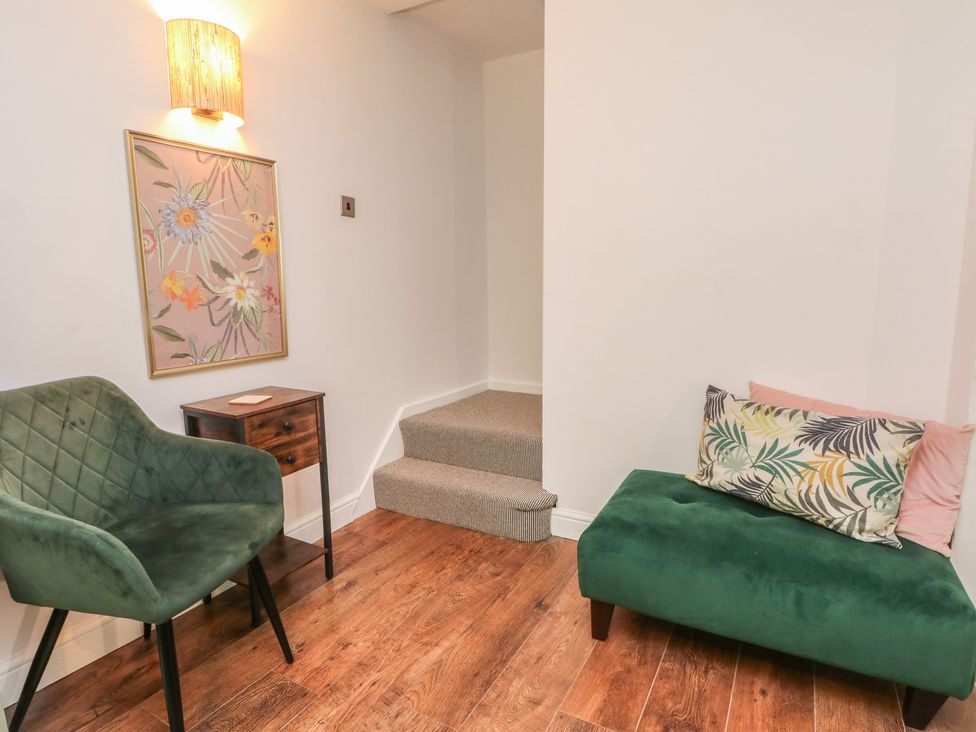 A living room with an armchair and a sofa at Coastal Cottage in Lytham St. Annes