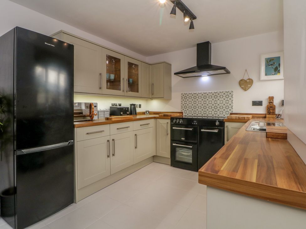 A kitchen with cabinets and appliances at Coastal Cottage in Lytham St. Annes