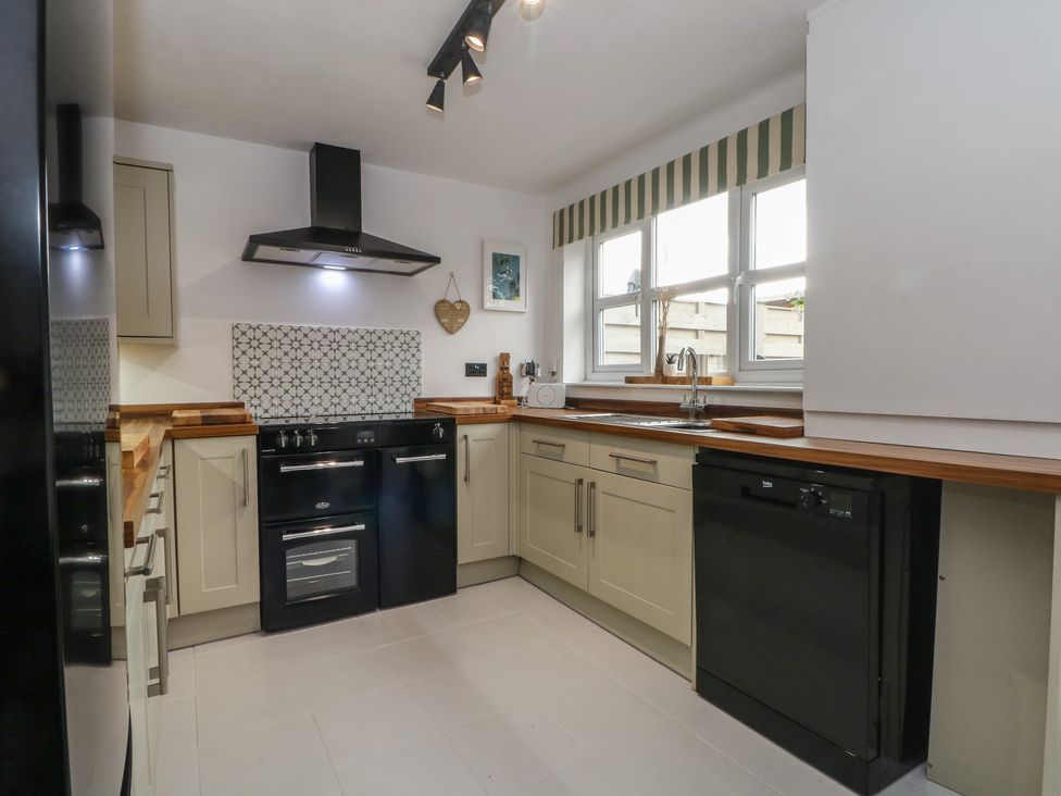 A kitchen with a stove and dishwasher at Coastal Cottage in Lytham St. Annes