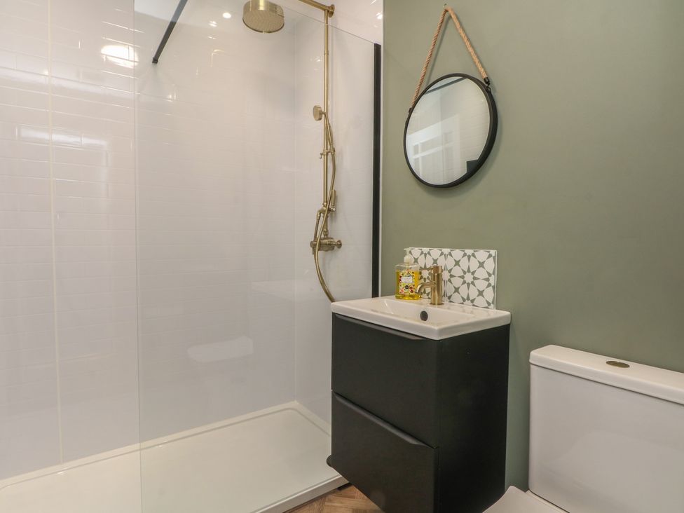 A bathroom featuring a shower, sink, and toilet at Coastal Cottage in Lytham St. Annes