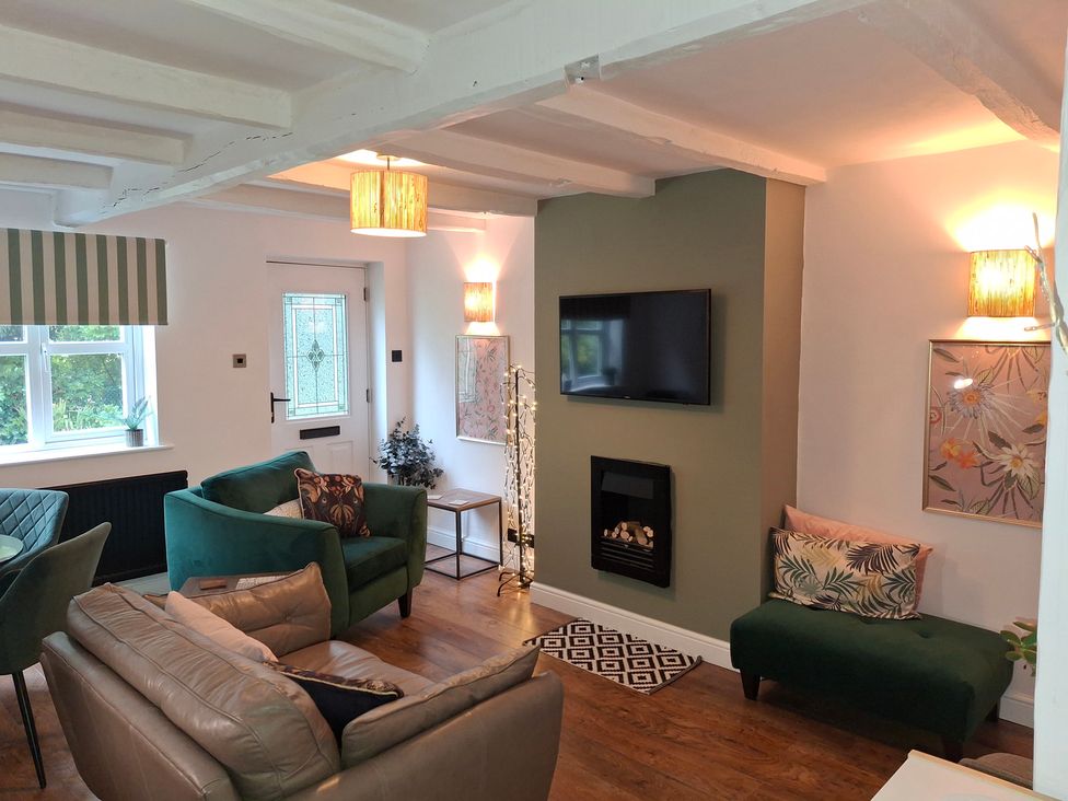 A living room with sofa and television at Coastal Cottage in Lytham St. Annes