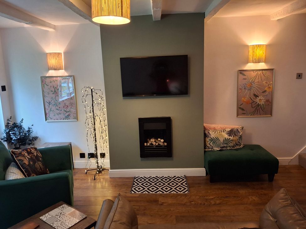 A living room with a television and fireplace at Coastal Cottage in Lytham St. Annes