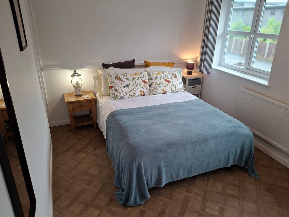 A bedroom with a bed and bedside table at Coastal Cottage in Lytham St. Annes