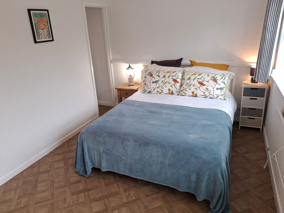 A bedroom with a bed and bedside table at Coastal Cottage in Lytham St. Annes