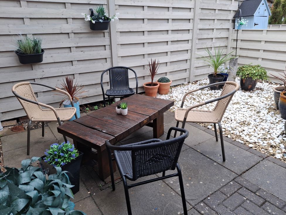 An outdoor seating area with a table and chairs at Coastal Cottage in Lytham St. Annes