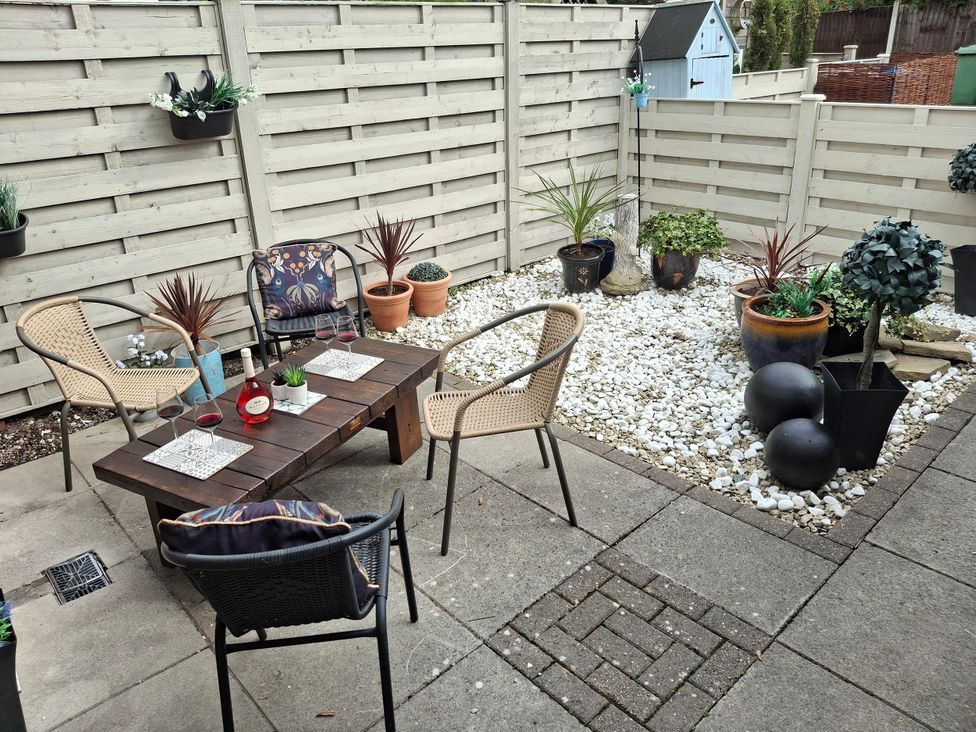 A garden with chairs and a table set for drinks at Coastal Cottage in Lytham St. Annes