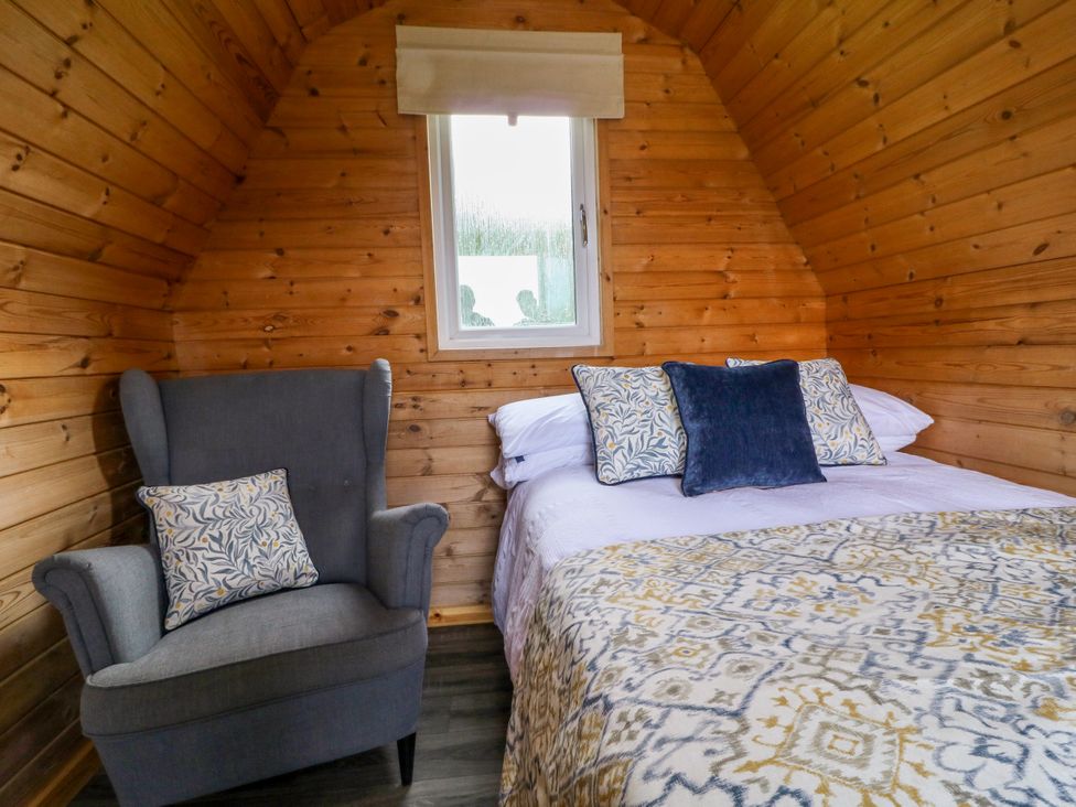 A bedroom with a bed and chair at Skylark Pod in Swannington near Coalville