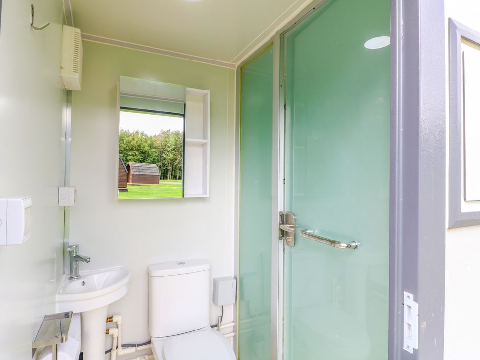 A bathroom with a sink, toilet, and shower at Skylark Pod in Swannington near Coalville