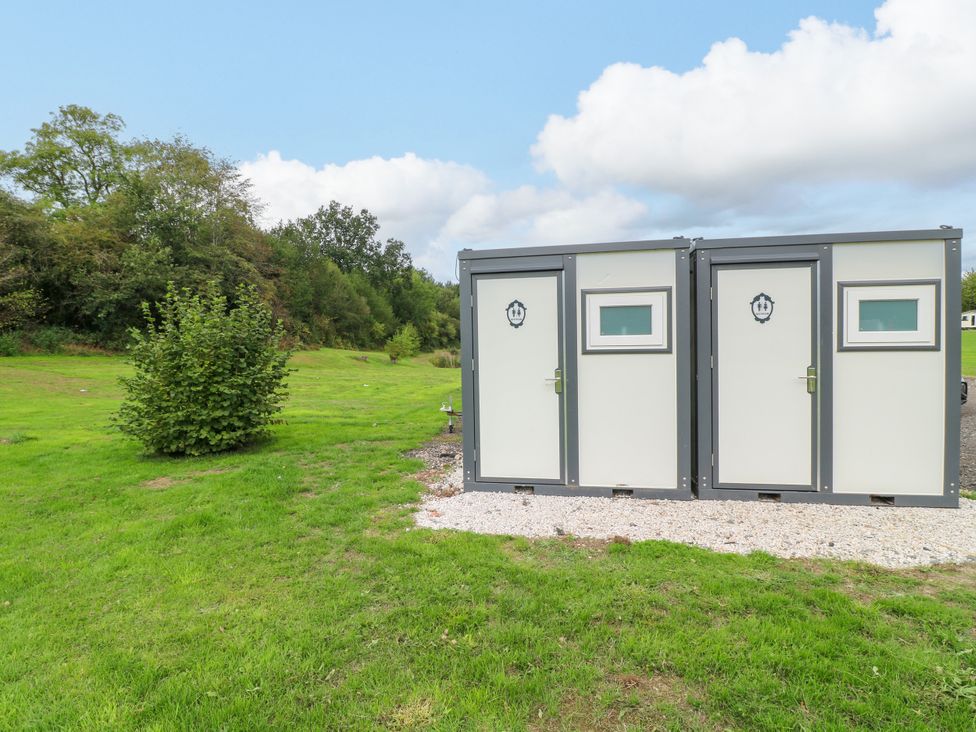 Toilet buildings with doors and windows in an outdoor area at Skylark Pod Swannington near Coalville