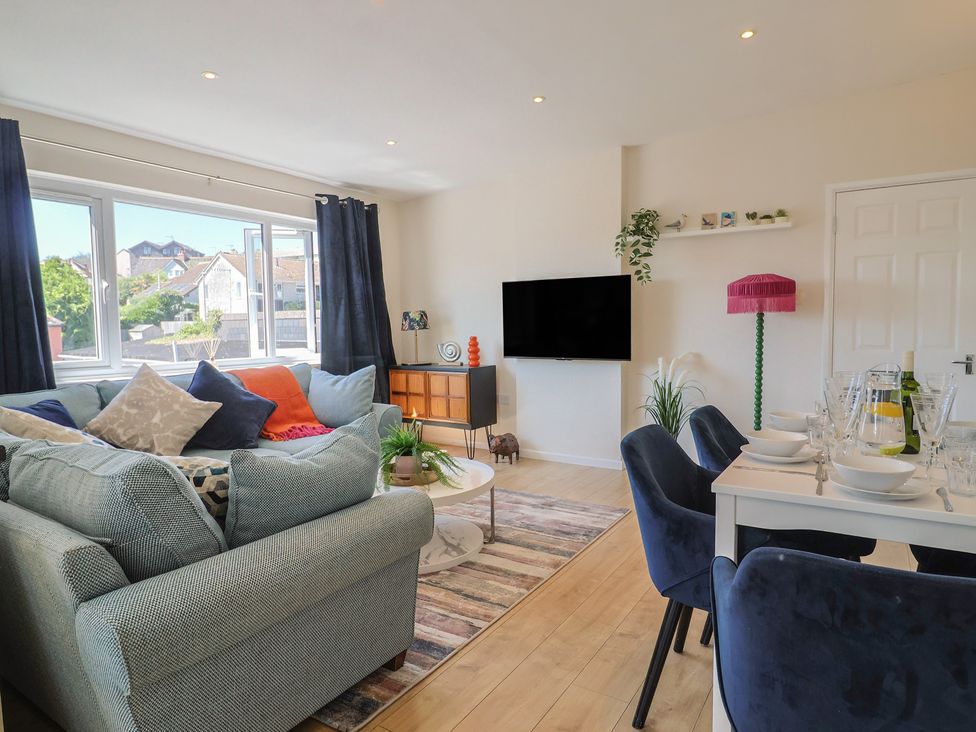 A living room with a sofa and dining area at 2 Mill Green Court Lyme Regis