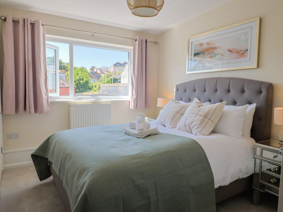 A bedroom with a bed and window at 2 Mill Green Court Lyme Regis