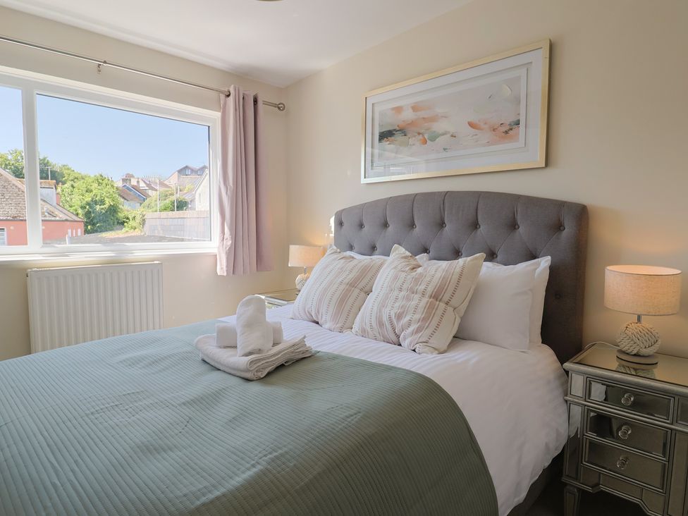 A bedroom with a bed and decorative pillow at 2 Mill Green Court in Lyme Regis