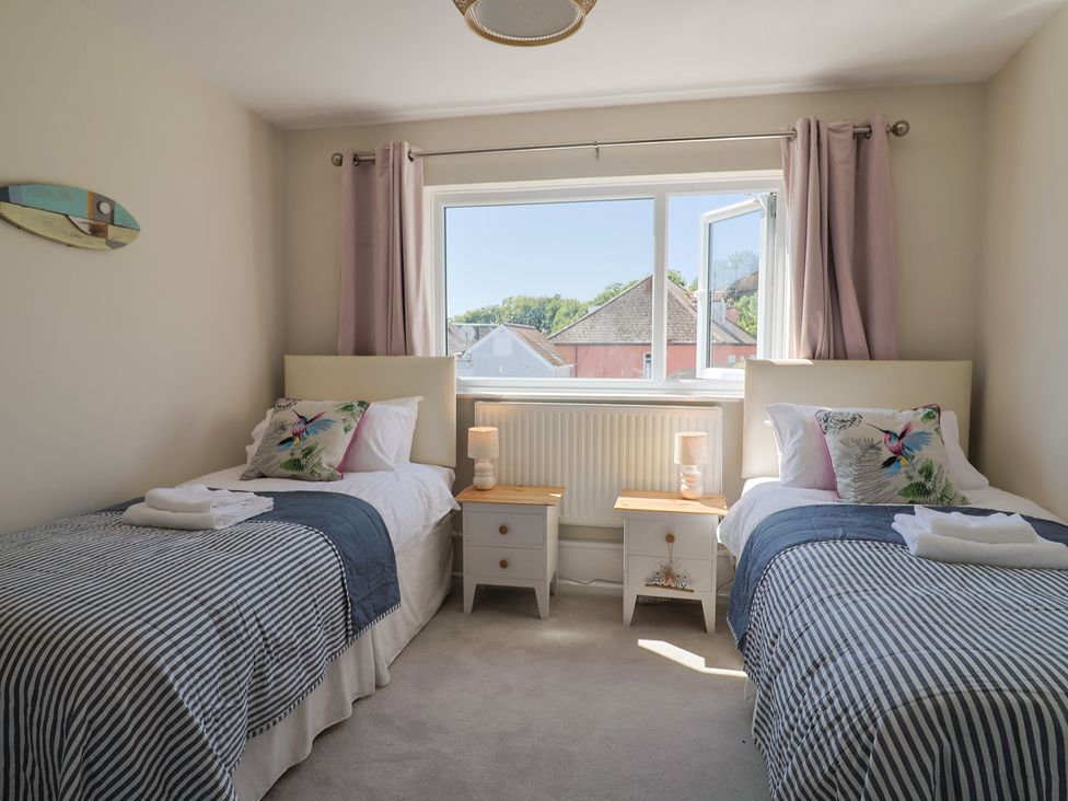 A bedroom with two beds and a window at 2 Mill Green Court Lyme Regis
