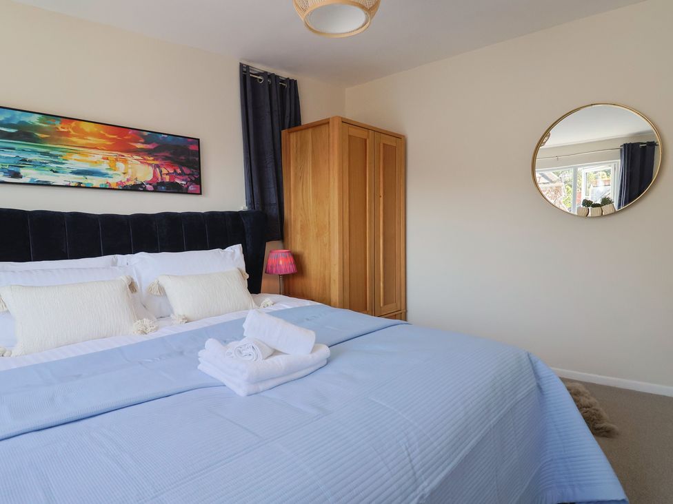 A bedroom with a bed and wardrobe at 2 Mill Green Court in Lyme Regis