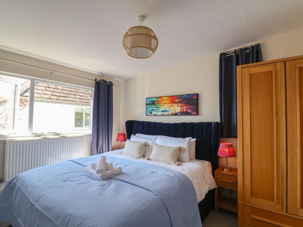 A bedroom with a bed and wardrobe at 2 Mill Green Court in Lyme Regis