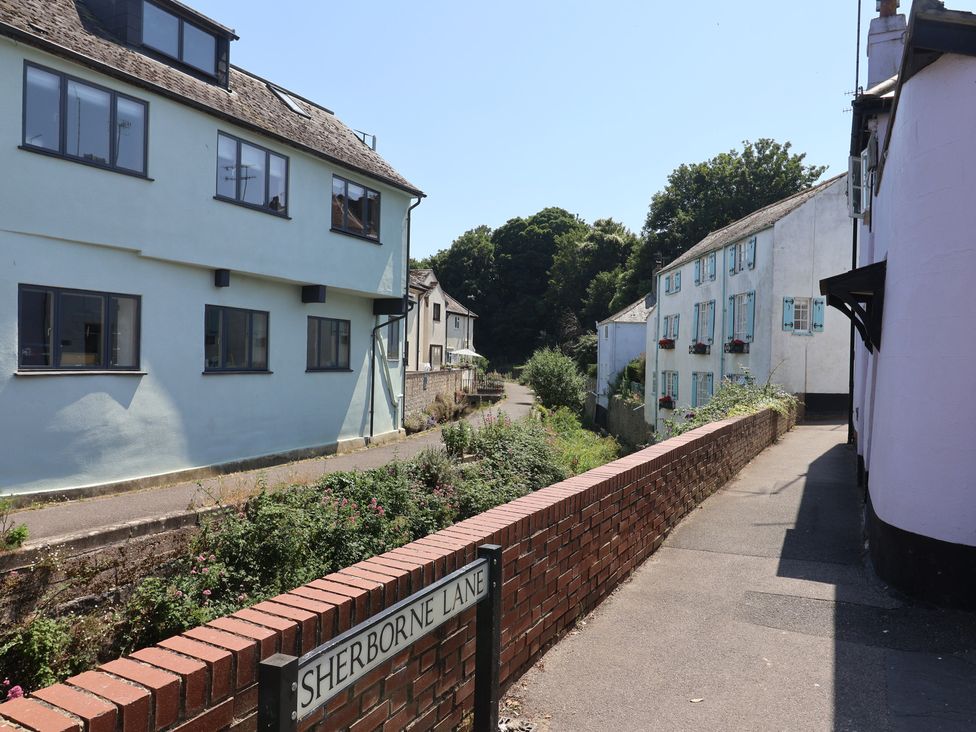 A street view featuring houses and a brick wall at 2 Mill Green Court in Lyme Regis