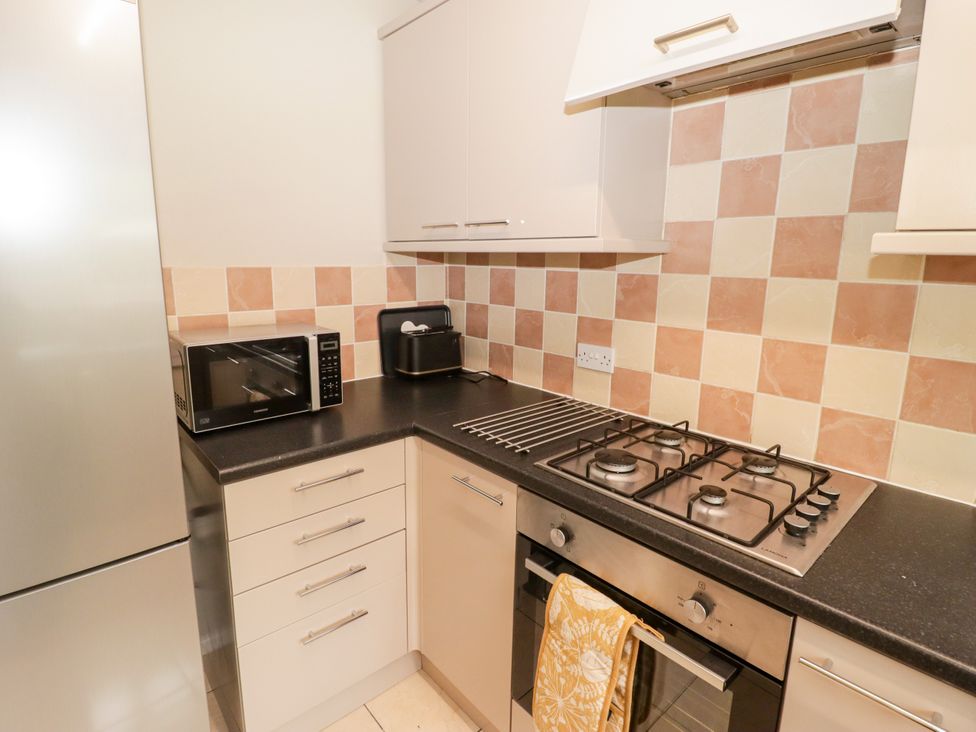 A kitchen with a microwave and gas stove at 7 Cwrt Y Cadno in Llantwit Major