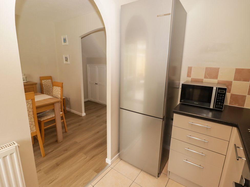 A kitchen with a refrigerator and a microwave at 7 Cwrt Y Cadno in Llantwit Major