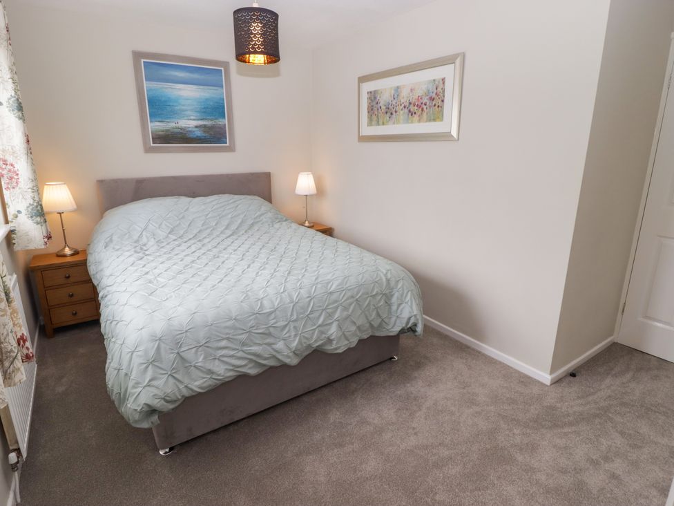 A bedroom with a bed and bedside tables at 7 Cwrt Y Cadno in Llantwit Major