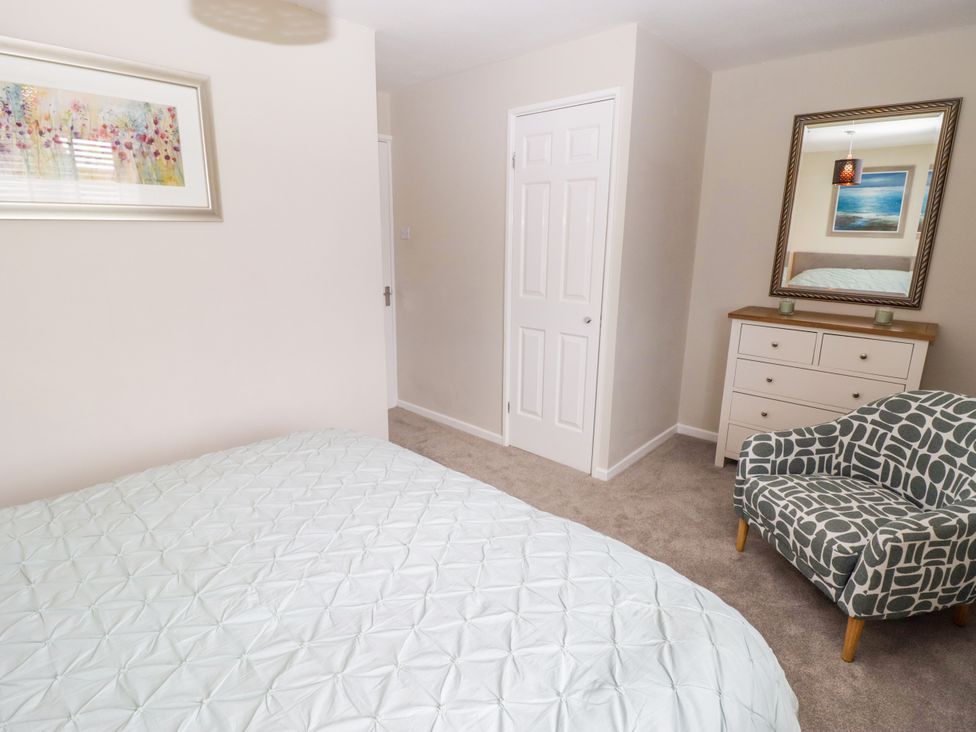 A bedroom with a bed and chair at 7 Cwrt Y Cadno in Llantwit Major